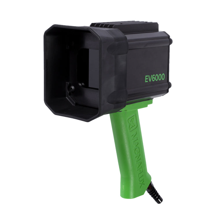 A hand-held Magnaflux EV6000 LED UV black light lamp with a green handle and black body.